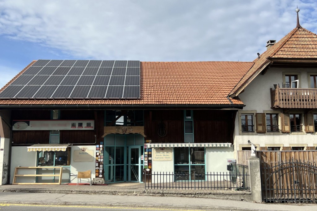 Façade de la sellerie avec panneaux photovoltaïques sur la toiture à Vuadens