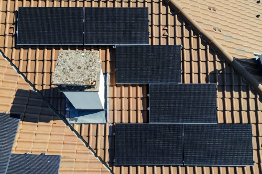 Vue zénithale des panneaux solaires posés autour de la cheminée à Givrins