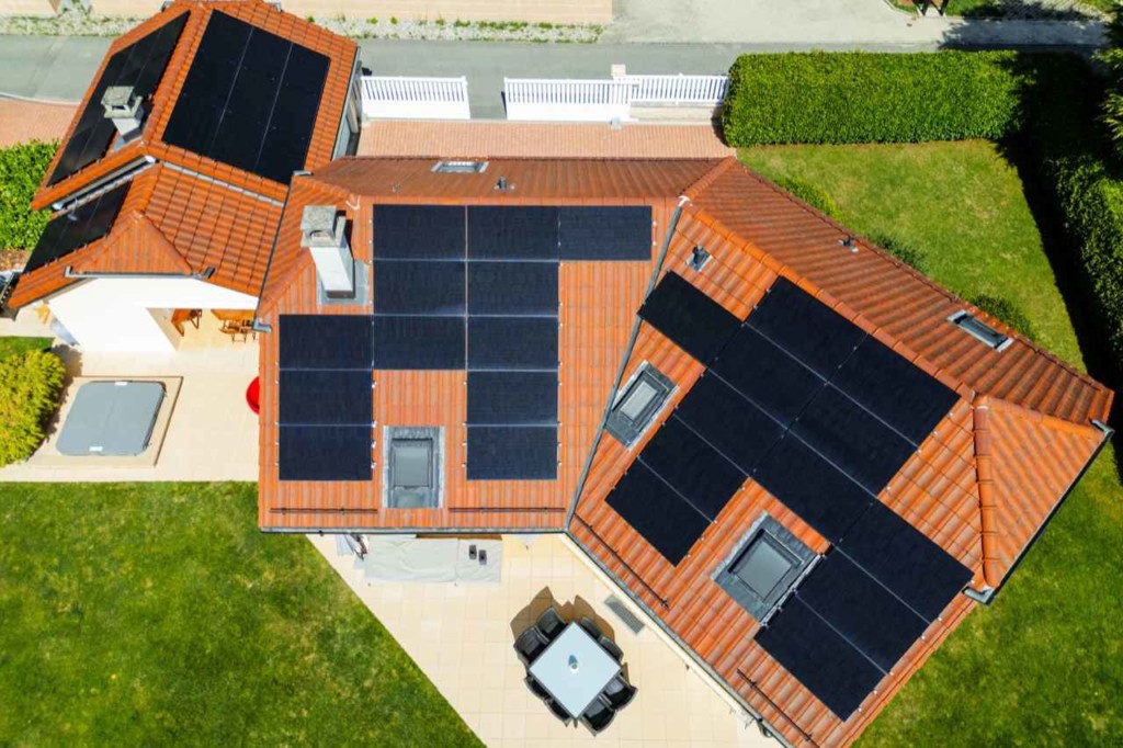 Vue aérienne des panneaux solaires répartis sur les pans de toiture à Genolier