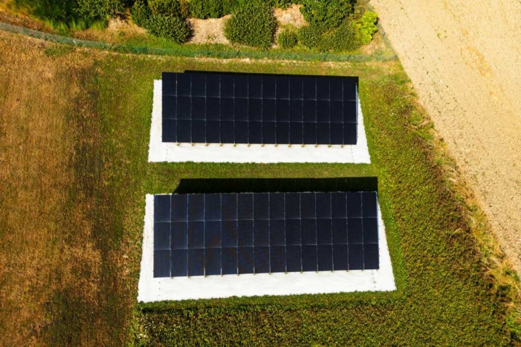 Vue aérienne des deux rangées de panneaux solaires au sol à Founex