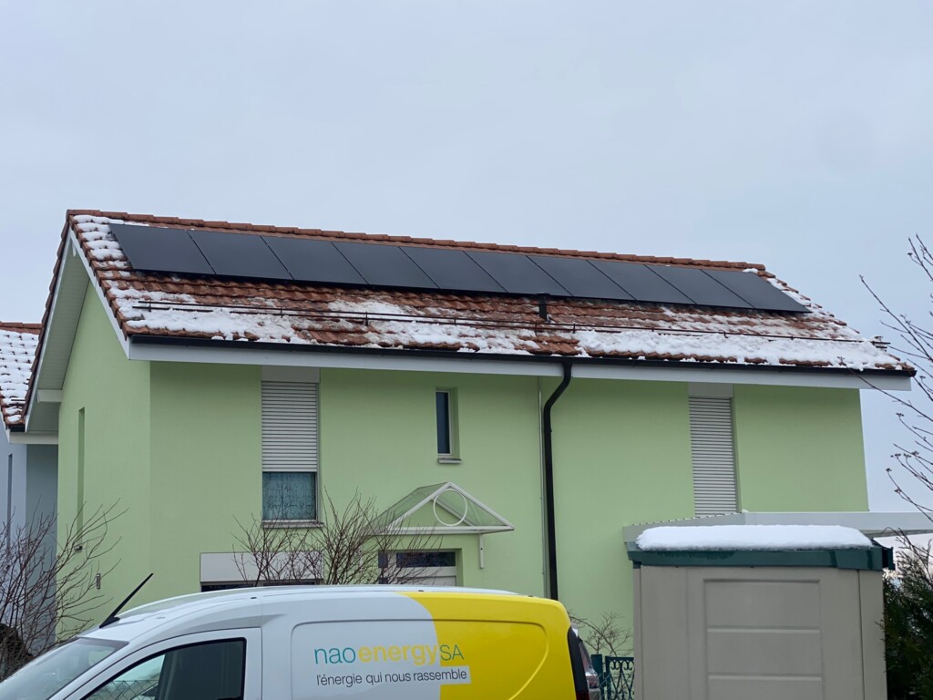 vue aérienne d'une installation de panneaux photovoltaïques sur toit d'une maison en suisse