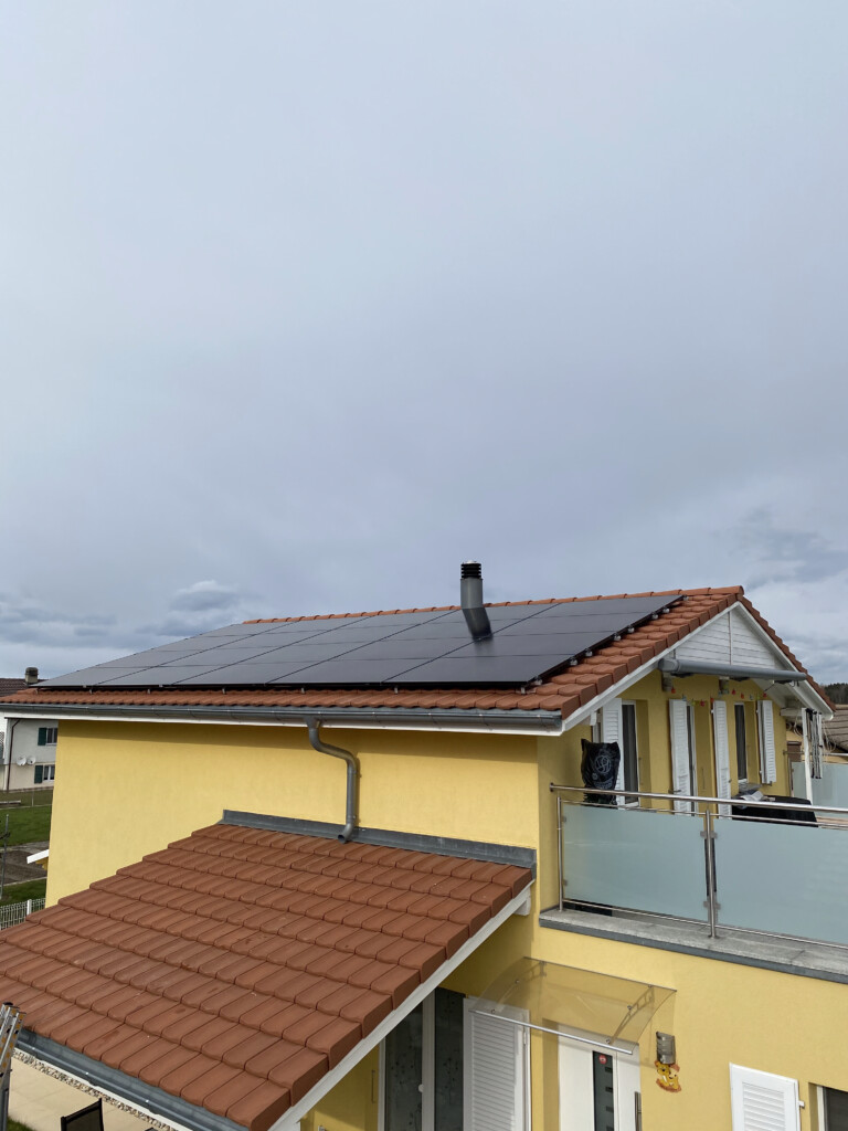 vue aérienne d'une installation de panneaux photovoltaïques sur toit d'une maison en suisse