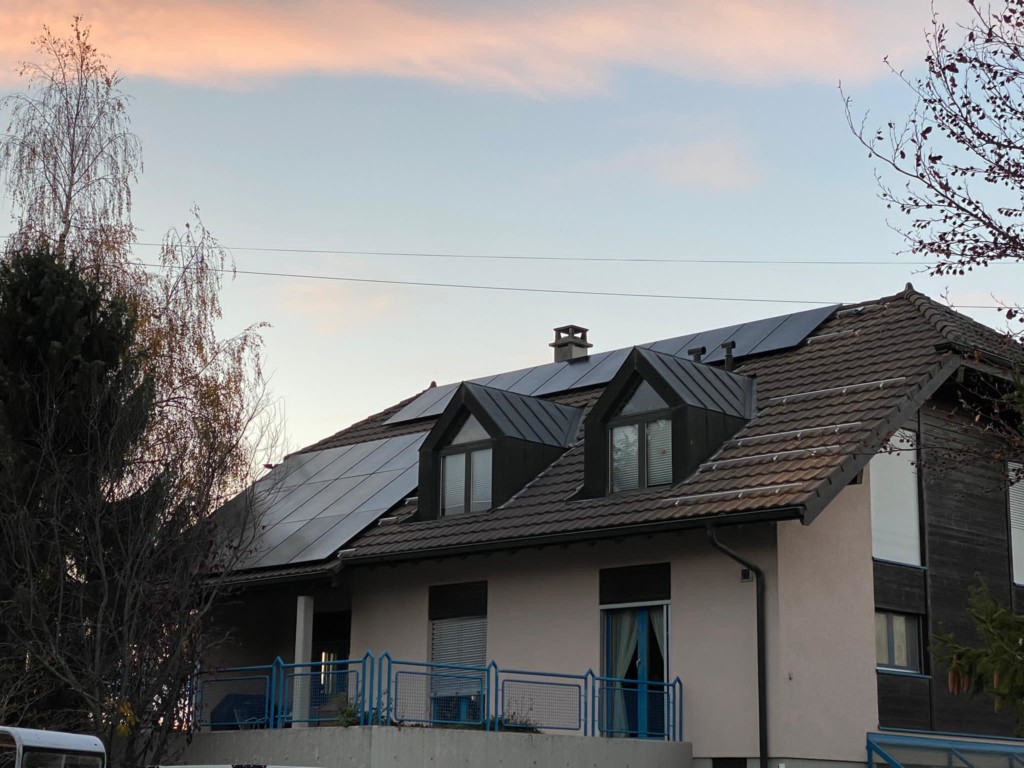 un toit avec des panneaux solaires dans le canton de Genève à la tombée de la nuit
