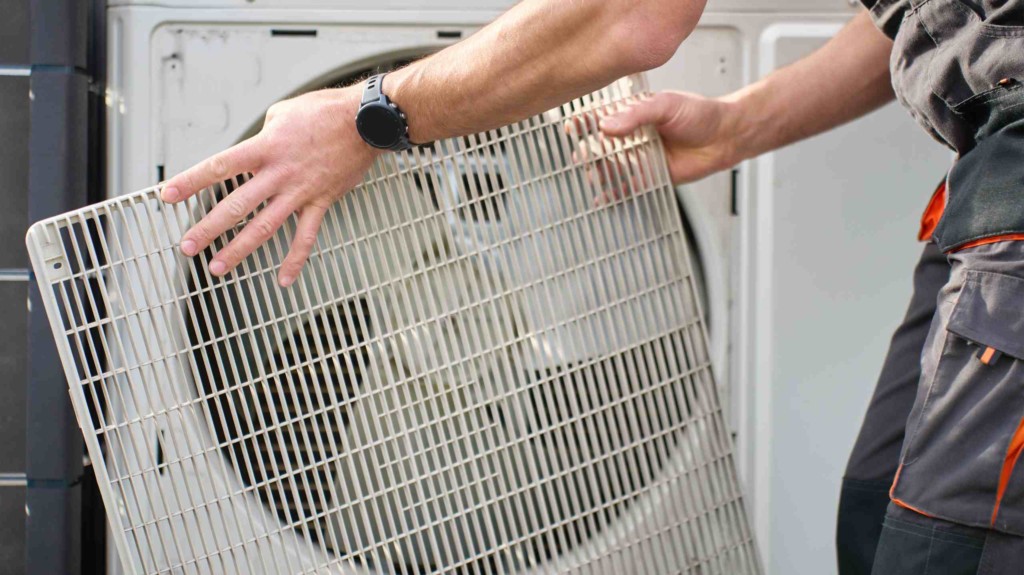 Un technicien entretient une pompe à chaleur en Suisse romande